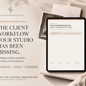 Puede incluir: Una tableta digital que muestra The Interior Designer Client Workflow System, con 65 herramientas rellenables, 5 archivos PDF y un flujo de trabajo de 11 etapas. El texto incluye Mein Lieblingsmoment Atelier, Interior Designer Business Toolkit y Master + Studio + Client-Facing + Shared Project Packs.