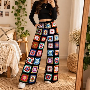 May include: High-waisted wide-leg pants featuring a colorful granny square crochet pattern. The pants are constructed from individual square motifs in various bright colors including red, blue, yellow, and green, all bordered by black yarn.