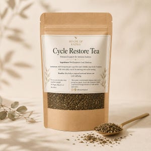 Peut inclure: Un sachet en papier kraft brun de thé Cycle Restore Tea de House of Rapha avec une étiquette blanche et du texte noir, incluant des ingrédients comme la feuille de framboisier et la damiana, poids net 100g, avec une cuillère dorée remplie de thé.