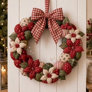 May include: A circular fabric wreath featuring a large red and white gingham bow at the top. The wreath is constructed from stuffed fabric spheres and star-shaped flowers in shades of red, dark green, and cream, accented with small red berries.