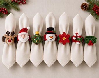 May include: Seven off-white cloth napkins held by crocheted Christmas napkin rings featuring a reindeer, Santa Claus, a green Christmas tree, a snowman, a red poinsettia, a red and white candy cane, and a green holly leaf with red berries.