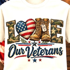 May include: A white t-shirt featuring the word LOVE with a heart patterned like the American flag and a pair of tan combat boots replacing the letter V. The text Our Veterans is printed below in blue script with small red and blue stars.