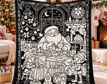 Puede incluir: Una manta de forro polar en blanco y negro con una detallada ilustración de líneas que muestra a Santa Claus trabajando en un banco de trabajo con dos elfos, rodeado de regalos de Navidad, un árbol decorado y juguetes.