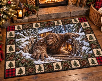 Puede incluir: Un tapete rectangular con una ilustración central de una criatura Bigfoot marrón y peluda emergiendo de una escalera de piedra nevada cerca de una cabaña. El borde muestra un patrón repetitivo de pinos, piñas y cuadros rojos.