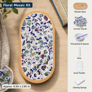 May include: A floral mosaic kit featuring an oval wooden base filled with blue, green, and red patterned ceramic shards. The kit includes a wooden base, ceramic shards, a mixing bowl, a spatula, glue, grout powder, and a cleaning sponge.