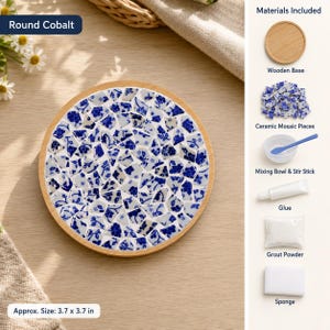 May include: A round cobalt mosaic craft kit featuring a circular wooden base, blue and white floral ceramic pieces, a mixing bowl with a stir stick, glue, grout powder, and a sponge. The finished project measures approximately 3.7 by 3.7 inches.