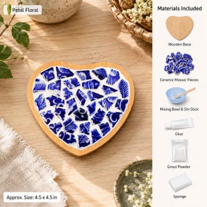 May include: A heart-shaped DIY mosaic kit featuring a wooden base, blue and white ceramic shards, glue, grout powder, a mixing bowl, a stir stick, and a sponge. The finished piece measures approximately 4.5 by 4.5 inches and is labeled Petal Floral.