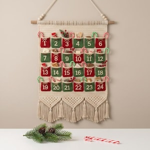 May include: A cream-colored macrame wall hanging advent calendar featuring twenty-four alternating red and green pockets numbered one through twenty-four. Each pocket contains small items and is decorated with miniature candy canes and greenery.