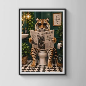 Könnte beinhalten: Ein gerahmter Kunstdruck, der einen Tiger mit Sonnenbrille zeigt, der auf einer weißen Toilette sitzt und eine Zeitung namens The Daily Roar liest. Der Hintergrund ist ein dunkelgrünes Badezimmer mit Schachbrettboden und einer Pflanze.