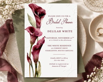 May include: A white rectangular bridal shower invitation card featuring a watercolor illustration of deep burgundy calla lilies on the left side. The text includes the name Delilah White, the date November 14th, and the location in South Carolina.