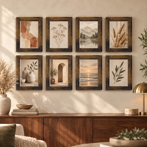 May include: A set of eight rectangular wall frames with dark, distressed wood finishes, arranged in two rows of four. Each frame contains a different print, including abstract shapes, botanical illustrations, mountain landscapes, and coastal sunset scenes.