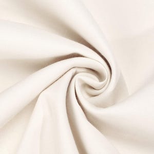 May include: A solid off-white fabric with a smooth, matte texture, arranged in a tight, swirling spiral pattern that creates deep, soft folds and shadows, highlighting the consistent colour and the fine, woven nature of the textile material.