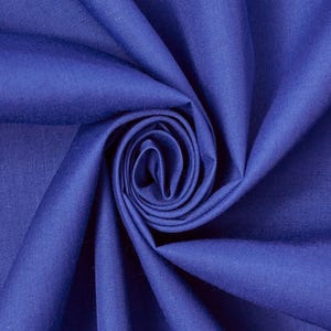 Puede incluir: Una tela de color azul real sólido con una textura suave y mate, dispuesta en un pliegue en espiral central que crea pliegues profundos y radiantes y sombras en la superficie, resaltando el color consistente y el tejido fino del material.
