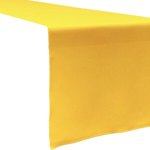 May include: A solid bright yellow rectangular table runner made of fabric. The runner features a smooth, uniform texture and clean, straight edges, designed to lay flat across a table surface with a simple, unadorned appearance.