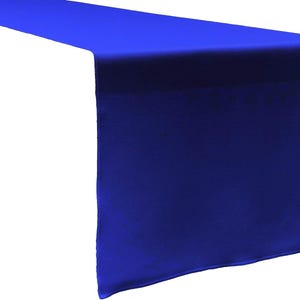 Peut inclure: Un chemin de table bleu roi uni avec une finition lisse et satinée. Le tissu est rectangulaire et présente des bords nets et droits, drapé pour montrer une longue section horizontale et une chute verticale, affichant une couleur vive.