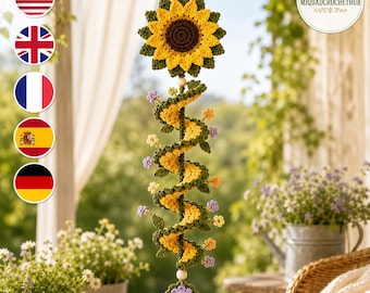 May include: A hanging crochet decoration featuring a large yellow and brown sunflower at the top, followed by a long, spiraling green and yellow vine adorned with small purple and orange flowers, ending with a single purple and yellow flower.