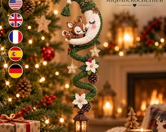 May include: A crocheted hanging ornament featuring a sleeping fawn nestled on a cream-colored crescent moon with a green nightcap. The design includes a spiraling green vine adorned with white flowers, pinecones, red berries, and a small lantern.