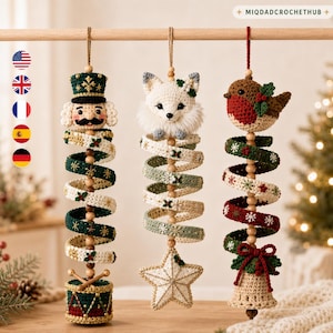 Pode incluir: Três ornamentos de crochê pendurados com um quebra-nozes, uma raposa branca e um pisco-de-peito-ruivo. Cada ornamento tem um corpo em espiral com contas de madeira e bordados festivos. O quebra-nozes assenta num tambor, a raposa sobre uma estrela.