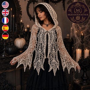 May include: A beige crochet hooded capelet featuring an intricate web-like pattern with pointed, jagged hem edges. The garment is secured at the neckline with a decorative metal clasp and is worn over a solid black dress. The design includes a hood.