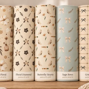 May include: Five cylindrical fabric rolls featuring distinct patterns: Vase Floral with flowers and vases, Floral Diamond with dark flowers, Butterfly Hearts with butterflies and hearts, Sage Bows with light bows, and Grid Bows with a black grid pattern.