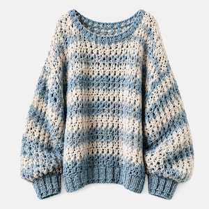 Könnte beinhalten: Ein langärmeliger Pullover mit einer lockeren, offen gestrickten Häkelstruktur und abwechselnden horizontalen Streifen aus hellblauem und cremeweißem Garn. Das Kleidungsstück hat einen weiten Rundhalsausschnitt sowie gerippte Bündchen und Saum in Blau.
