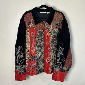 May include: A long-sleeve button-down jacket featuring a patchwork design with black velvet panels, red fabric sections, and a leopard print accent. The garment is decorated with intricate floral embroidery and metallic thread detailing throughout.
