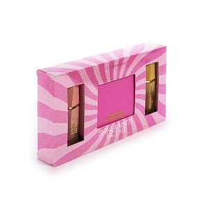 Op de afbeelding: Een rechthoekige doos met een roze en lichtroze wervelpatroon met een Shine & Matte Face Kit. De set bevat een vloeibare blush, een pakje matterende vloeipapiertjes en een vloeibare highlighter, allemaal zichtbaar door het venster.