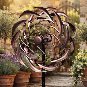May include: A copper-colored metal wind spinner featuring multiple curved, blade-like petals arranged in a circular, rotating pattern. The structure is mounted on a central black vertical pole, showcasing a metallic finish with dark accents.