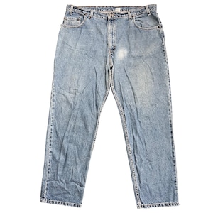 May include: Light blue denim jeans featuring a classic five-pocket design, a button fly closure, and a waistband with belt loops. The fabric displays a faded wash with subtle whiskering and a lighter bleached area on the upper right thigh.