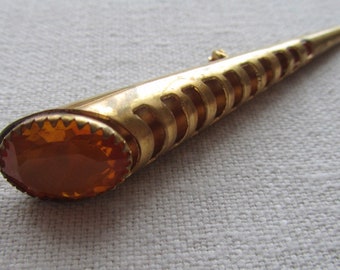Vintage gold tone torch brooch with yellow rhinestones