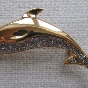 Vintage gold tone dauphin brooch with rhinestones