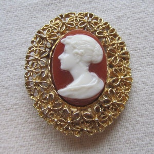 Vintage gold tone filigree plastic cameo brooch