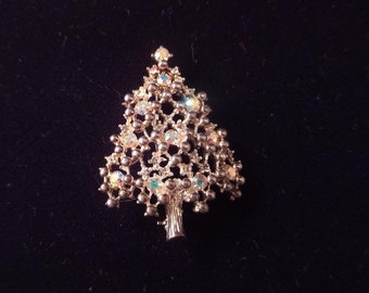 May include: A gold-tone Christmas tree brooch with iridescent rhinestones and a beaded design.