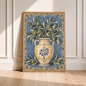 May include: A rectangular wall art print featuring a cream-coloured ceramic vase with two handles, decorated with a blue olive tree motif. The vase holds olive branches with green and black olives against a blue background, framed by a gold border.