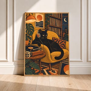 May include: A framed wall art print depicting a black cat wearing headphones, lounging on a yellow armchair. The scene includes a record player on a side table, a mug, a bookshelf, a potted plant, and a wall hanging with a sun and wave design.