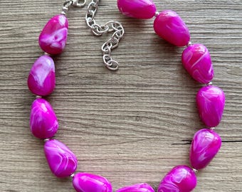 Puede incluir: Un collar rosa y blanco con una cadena plateada. El collar está hecho de cuentas grandes en forma de lágrima.