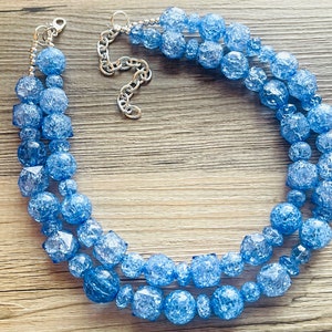 May include: A double-strand necklace made of light blue faceted glass beads. The necklace has a silver chain clasp.