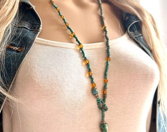 May include: A long turquoise and amber beaded necklace with a knotted turquoise pendant.