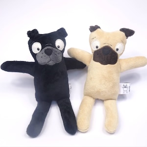 Könnte beinhalten: Zwei Plüsch-Mops-Spielzeuge, eines schwarz und eines braun, mit großen Augen und einem albernen Ausdruck. Beide Spielzeuge haben ein kleines Etikett an ihrem Fuß.