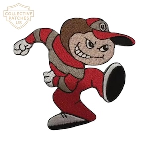 May include: An embroidered patch featuring a cartoon character in a dynamic running pose. The character wears a red and grey striped long-sleeve shirt, red pants, and a red and grey baseball cap with a letter O. The character has white gloves.