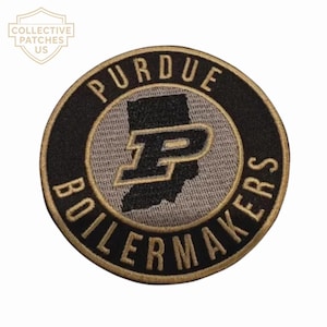 Könnte beinhalten: Ein kreisförmiger bestickter Aufnäher mit schwarzem Rand und dem goldenen Schriftzug PURDUE BOILERMAKERS. In der Mitte befindet sich eine graue Silhouette des Bundesstaates Indiana mit einem großen schwarz-goldenen P-Logo.