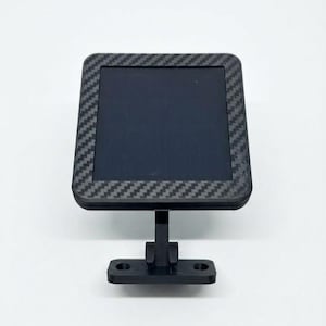 May include: A square display screen featuring a black carbon fiber patterned frame. The screen is mounted on a black adjustable stand with a flat base that includes two circular screw holes for mounting purposes, providing a stable support.