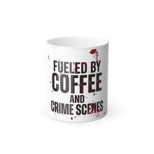 May include: A white ceramic mug featuring the black text FUELED BY COFFEE AND CRIME SCENES. The design includes red splatters resembling blood droplets scattered across the surface, integrated with the lettering and around the mug exterior.