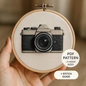 May include: A circular wooden embroidery hoop containing a fabric panel with a stitched camera design in black and beige thread. The text PDF PATTERN +4 HOOP SIZES and + STITCH GUIDE is overlaid on the right side of the image.