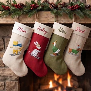 May include: Four Christmas stockings with cream-colored cuffs embroidered with the names Mom, Haley, Alex, and Dad. The stockings feature embroidered animals skiing: a yellow cat, a white rabbit, a goose, and a dachshund, all wearing winter clothing.