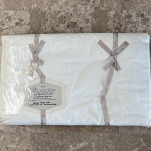Puede incluir: Una s&aacute;bana bajera doble blanca Wamsutta Supercale Plus empaquetada en pl&aacute;stico transparente con cintas de marca. La etiqueta especifica 200 hilos por pulgada cuadrada, 50% poli&eacute;ster Fortrel y 50% algod&oacute;n peinado, para un colch&oacute;n de 137 x 190 cm.