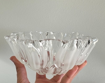 May include: A clear glass bowl featuring a scalloped, petal-like rim and a frosted, matte finish on the exterior vertical panels. The bowl has a rounded base and a wide, open top, with alternating clear and frosted glass sections.