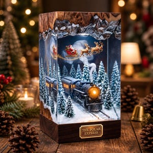 Könnte beinhalten: Eine rechteckige Kunstharzlampe mit einer Winterszene, die eine Dampflokomotive auf Schienen, schneebedeckte Tannen und den Weihnachtsmann im Schlitten mit Rentieren zeigt. Der Sockel ist aus dunklem Holz mit einer goldenen Plakette THE POLAR EXPRESS.