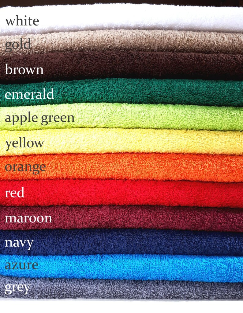 May include: A stack of towels in various colors, including white, gold, brown, emerald, apple green, yellow, orange, red, maroon, navy, azure, and grey.