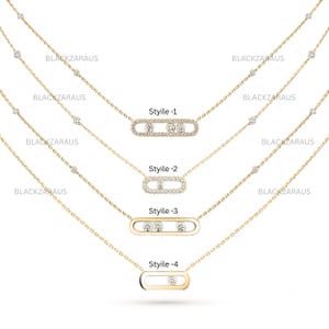Könnte beinhalten: Vier Goldhalsketten mit feinen Ketten und kleinen gefassten Steinen. Jede Halskette hat einen zentralen horizontalen ovalen Anhänger mit unterschiedlichen Diamantkonfigurationen, beschriftet mit Style-1, Style-2, Style-3 und Style-4 sowie dem Text BLACKZARAUS.